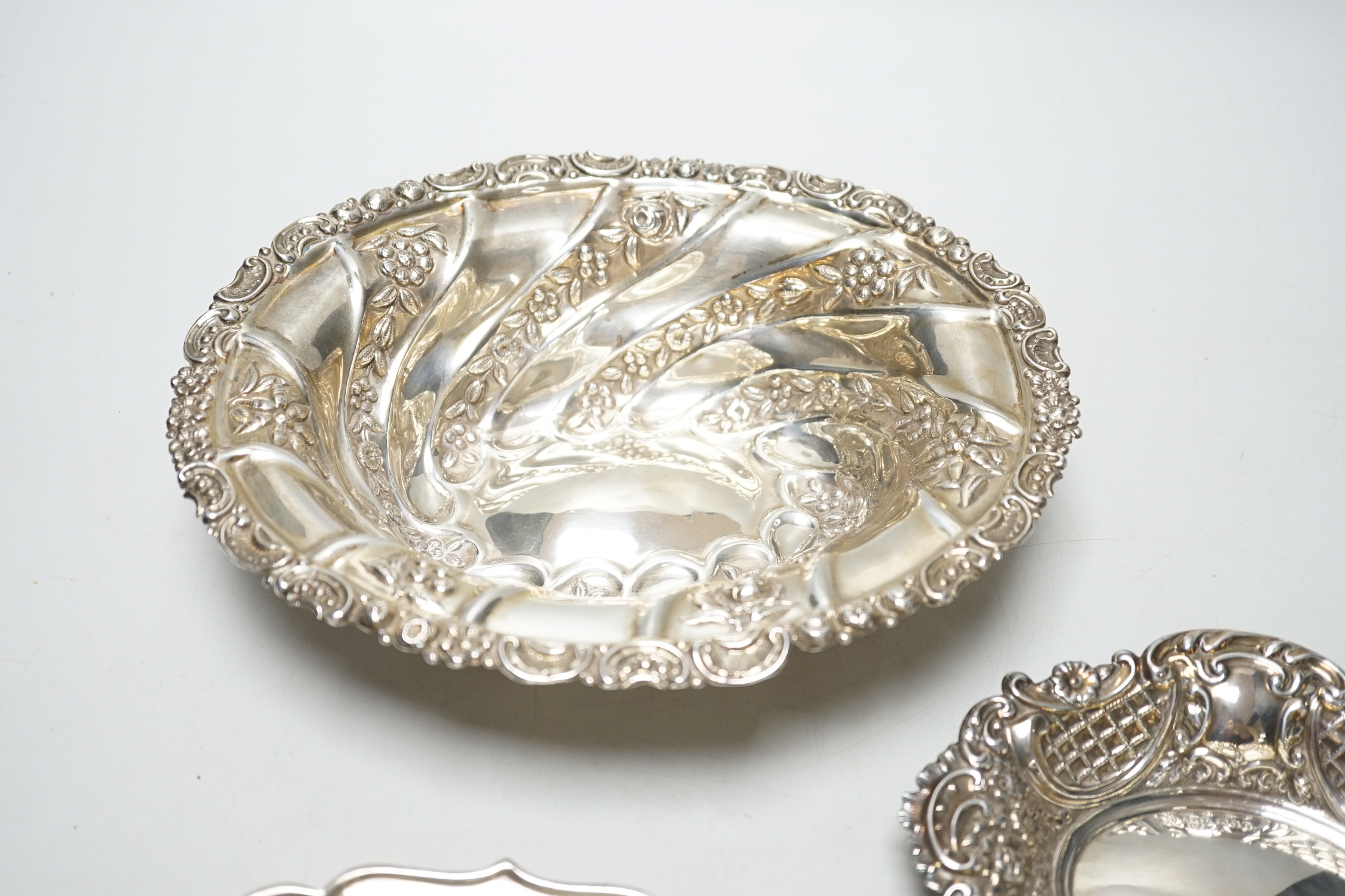 A late Victorian repousse silver oval bowl, William Comyns, London, 1889, 21.1cm and two other smaller silver dishes, 10.8oz.